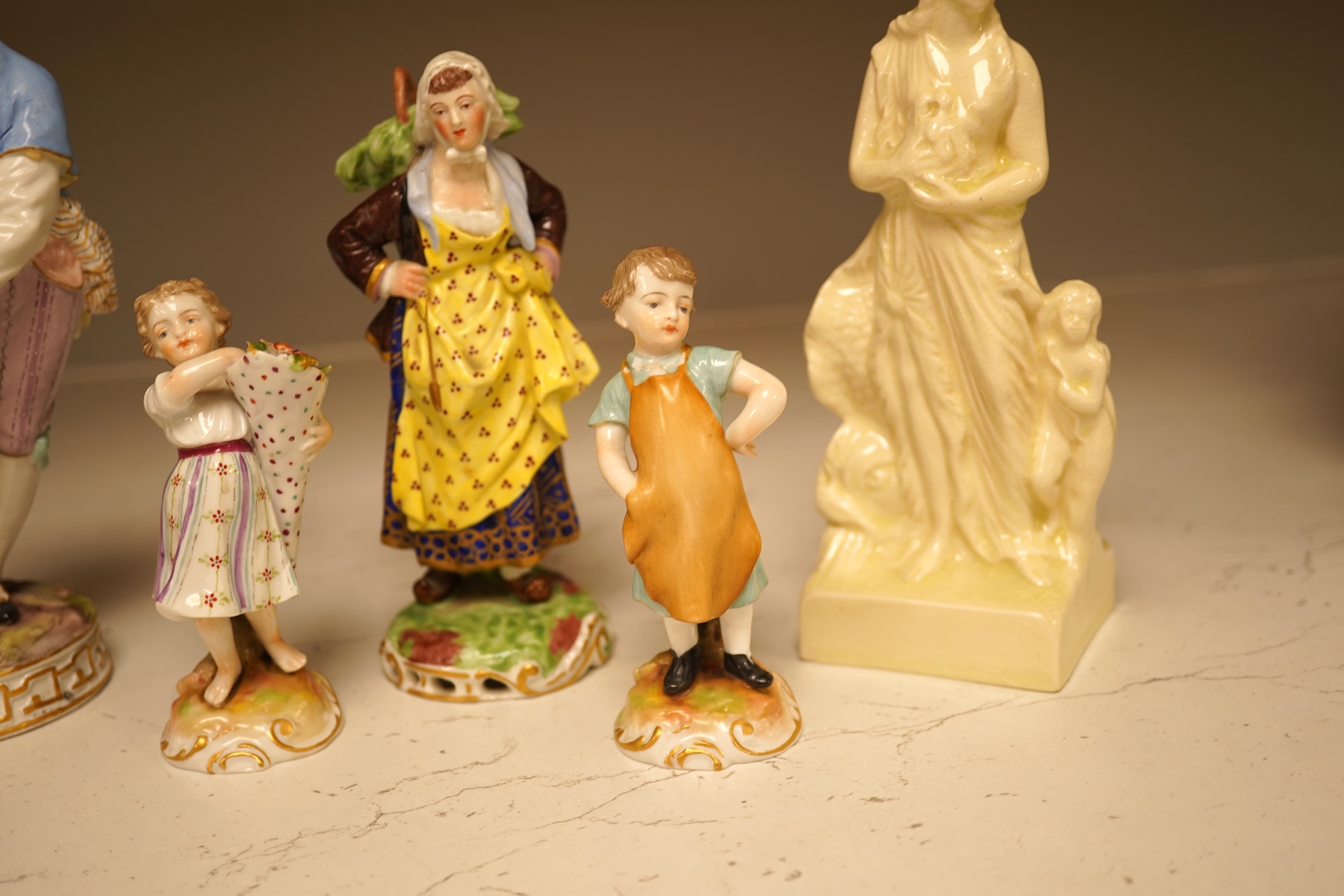 A pair of 19th century Meissen figurines, a Crown Derby figure, a pair of miniature figures and a Leeds type creamware group of Venus and Cupid, tallest 18cm high.